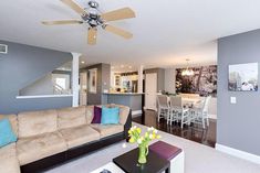 a living room filled with furniture and a ceiling fan