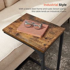 a wooden table with a book and glasses on it next to a couch in a living room