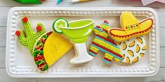 decorated cookies are sitting on a tray next to crayons and markers