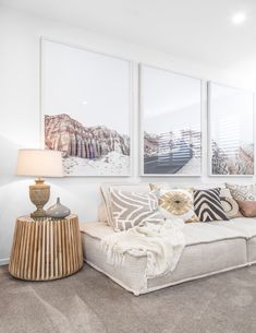 a living room filled with furniture and paintings on the wall above it's windows