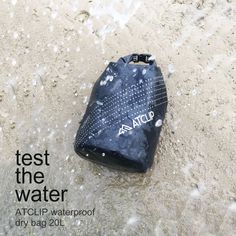 a water bag sitting on top of a sandy beach next to the words test the water