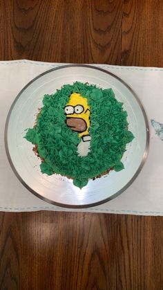 a cake that looks like the simpsons treehouse is made out of green frosting