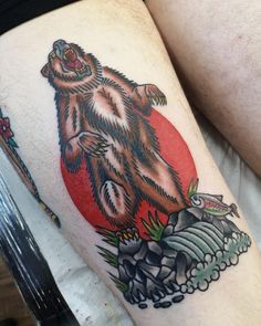 a man's thigh with a bear tattoo on it and an object in the background