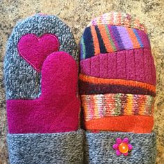 two oven mitts with hearts on them sitting on a counter next to each other