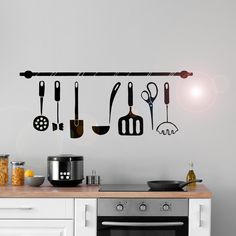 a kitchen wall with utensils hanging from it