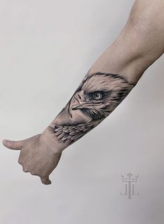 an eagle tattoo on the left arm and wrist is shown with its eyes open, while it