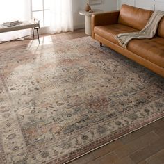 a living room area with a couch, chair and rug