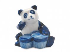 a blue and white panda bear figurine sitting on top of a cupcake