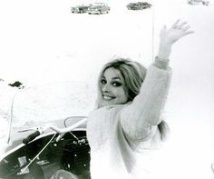 a black and white photo of a woman waving