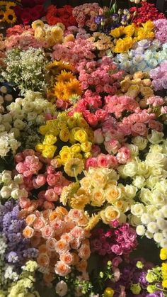 many different colored flowers are arranged together