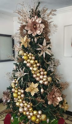 a christmas tree decorated with gold and silver ornaments