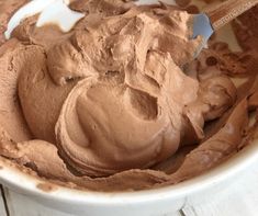 a bowl full of chocolate ice cream with a spoon in it