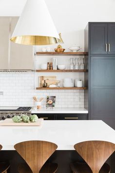 a kitchen with open shelvings like a boss, and brass lights hanging from the ceiling