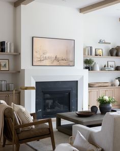 a living room filled with furniture and a fire place under a painting on the wall