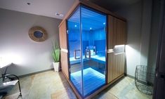 an indoor sauna is lit up with blue lights and wood accents in the room