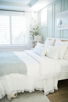 a white bed sitting in a bedroom next to a window