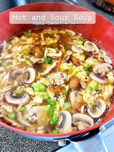 hot and sour soup in a red bowl with green onions, mushrooms, and rice