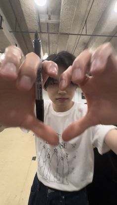 a young boy is holding his hands up to show the fingers that he has placed in front of him