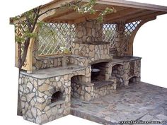 an outdoor stone pizza oven built into the side of a house