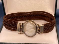 Antique Victorian 14kt cameo hair bracelet has an oval shell cameo in center which also serves as a clasp. It measures 21.5mm by 18mm. Note: safety chain is gold filled. 6.1g. Money back guarantee within 14days. Buyer pays return shipping and must be returned in original condition with box and no alterations. Elegant Adjustable Cameo Bracelets, Antique Oval Cameo Bracelet, Victorian Oval Brown Jewelry, Collectible Adjustable Cameo Jewelry, Victorian Style Oval Brown Jewelry, Victorian Brown Oval Jewelry, Brown Oval Victorian Jewelry, Oval Cameo Bracelet For Formal Occasions, Formal Adjustable Cameo Jewelry