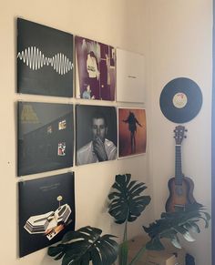 there are many pictures hanging on the wall next to a plant and a record player