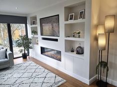 a living room filled with furniture and a fire place next to a wall mounted tv