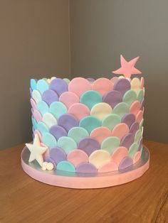 there is a cake that has been decorated with pastel colors and stars on it