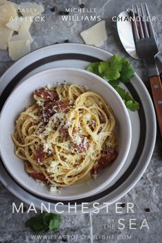 a white bowl filled with pasta and sauce on top of a table next to a knife and fork