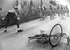 a group of bicyclists riding down a road next to a broken bike