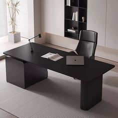 an office desk with a laptop on it in front of a bookcase and bookshelf