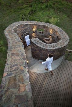 a man in white robe walking towards an outdoor hot tub