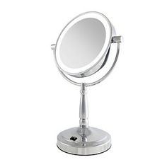 a small round mirror on top of a metal stand with one light on it's side