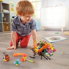 a young boy playing with toys on the floor