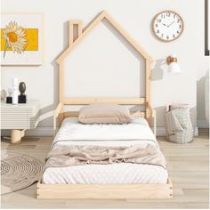 a bed with a house shaped headboard on top of it next to a clock