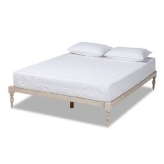 a white bed with two pillows on top of it