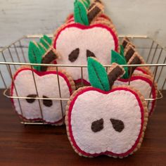 four decorated apple cookies in a wire basket