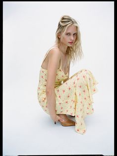 a woman sitting on the ground in a yellow dress