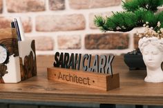 a wooden desk with a clock, pen holder and notepad on top of it