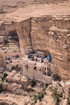 an aerial view of a village built into the side of a cliff in jordan valley