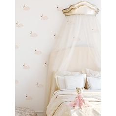 a bed with a canopy over it in a bedroom next to a wall papered with hot air balloons