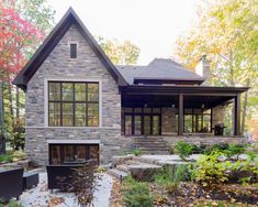 a stone house surrounded by trees in the fall