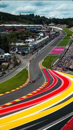 an aerial view of a race track with cars driving on it and spectators in the stands