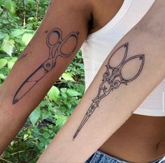 two tattoos with scissors on their arms