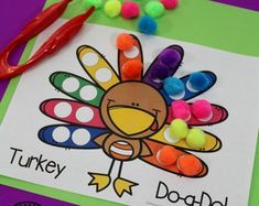 a turkey craft with pom - poms and scissors on a purple table top