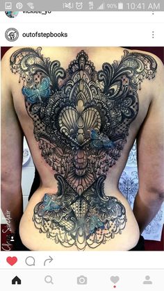 the back of a woman's body with intricate tattoos