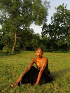 a naked woman sitting in the grass