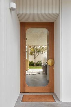 an entryway with a wooden door and white walls