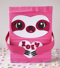 a pink paper bag with a slotty face on it and the word love is cut out