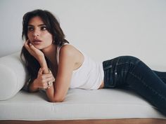 a beautiful woman laying on top of a white couch