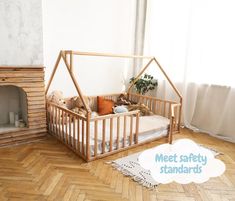 a wooden baby crib sitting on top of a hard wood floor next to a fire place